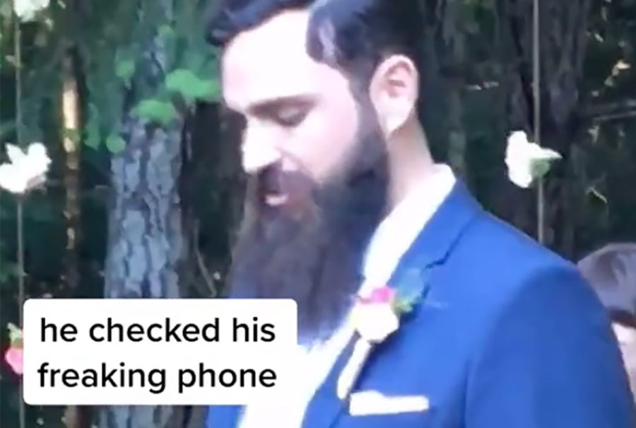 Novio mira su celular mientras su novia camina al altar